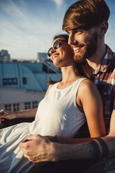Austria, Vienna, Young couple enjoying romantic sunset on rooftop terrace - AIF000120