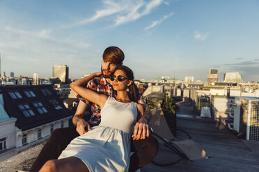 Austria, Vienna, Young couple enjoying romantic sunset on rooftop terrace - AIF000123