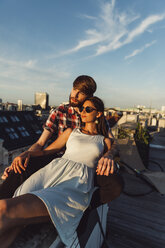 Austria, Vienna, Young couple enjoying romantic sunset on rooftop terrace - AIF000124