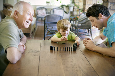 Little boy playing with his father and grandfather domino - RMAF000012