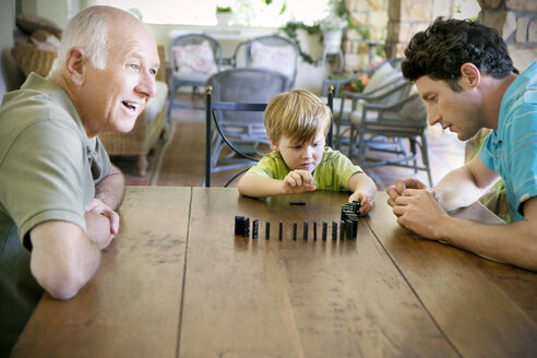 Little boy playing with his father and grandfather domino - RMAF000012