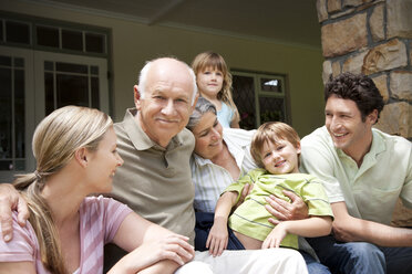 Gruppenbild einer Familie mit drei Generationen, die auf der Terrasse sitzt - RMAF000020