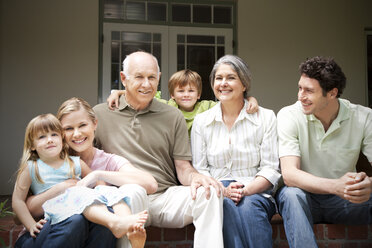 Gruppenbild einer Familie mit drei Generationen, die auf der Terrasse sitzt - RMAF000021
