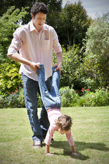 Mann spielt mit seiner kleinen Tochter im Garten - RMAF000043
