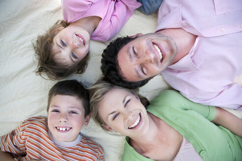 Gruppenbild einer glücklichen Familie, die zusammen auf einer Decke liegt - RMAF000051