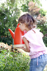 Little girl with watering can in the garden - RMAF000058