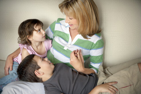 Kleiner Junge und kleines Mädchen mit ihrer Großmutter auf der Couch - RMAF000062