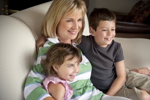 Kleiner Junge und kleines Mädchen mit ihrer Großmutter auf der Couch - RMAF000063