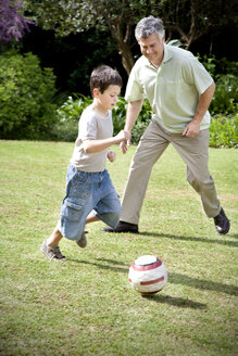 Little boy playing soccer with his grandfather - RMAF000070