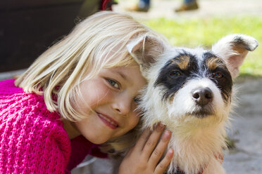 Porträt eines lächelnden kleinen blonden Mädchens und ihres Jack Russel Terriers - JFEF000730