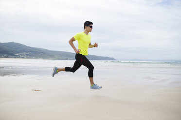 Spanien, Ferrol, junger Mann beim Joggen am Strand - RAEF000578