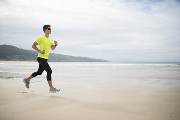 Spanien, Ferrol, junger Mann beim Joggen am Strand - RAEF000579