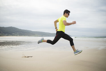 Spanien, Ferrol, junger Mann läuft am Strand - RAEF000580