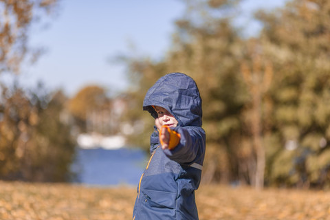 Kleiner Junge mit Regenjacke in der Natur, lizenzfreies Stockfoto