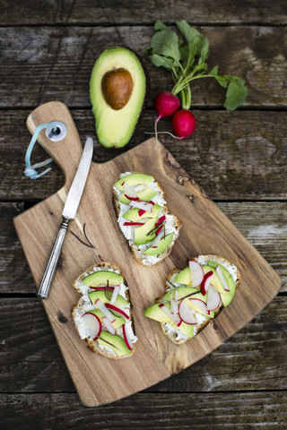 Avocado-Rettich-Brot auf Schneidebrett, lizenzfreies Stockfoto