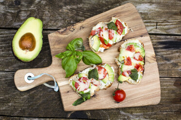 Avocado tomato cheese bread on chopping board - SARF002247