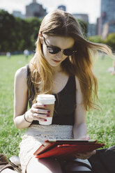 USA, New York City, young woman using digital tablet in Central Park - GIOF000351