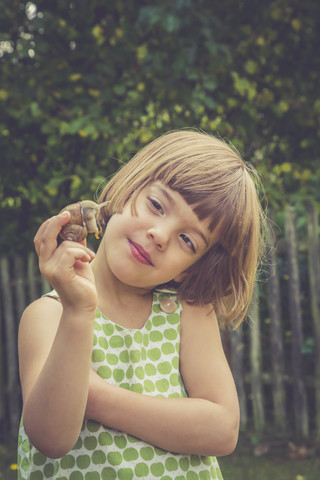 Porträt eines lächelnden kleinen Mädchens mit Weinbergschnecke, lizenzfreies Stockfoto