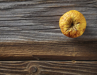 Shrivelled apple on rough wood - DISF002219