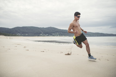 Spain, Ferrol, young man running fast on the beach - RAEF000598