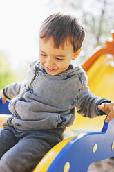 Glücklicher Junge auf einer Rutsche auf dem Spielplatz - EBSF000989