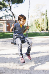 Junge auf einer Schaukel auf dem Spielplatz - EBSF000994