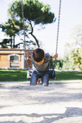 Junge auf einer Schaukel auf dem Spielplatz - EBSF000996