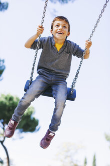 Glücklicher Junge auf einer Schaukel auf dem Spielplatz - EBSF000999