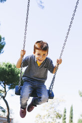 Glücklicher Junge auf einer Schaukel auf dem Spielplatz - EBSF001000
