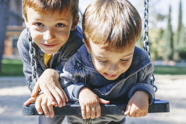 Zwei glückliche Jungen auf einer Schaukel auf dem Spielplatz - EBSF001005