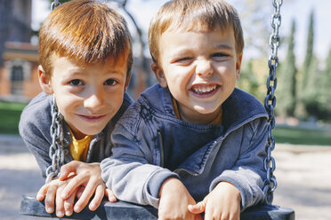 Zwei glückliche Jungen auf einer Schaukel auf dem Spielplatz - EBSF001006