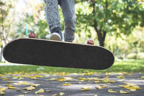 Junge mit Skateboard im Park im Herbst - DEGF000562