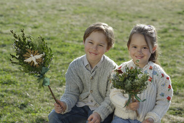 Deutschland, Oberbayern, kleiner Junge und Mädchen mit Palmbusch auf einer Wiese - LBF001269