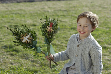 Germany, Upper Bavaria, Portrait of smiling little boy with Palmbusch on a meadow - LBF001270