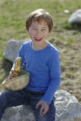 Porträt eines lachenden kleinen Jungen mit Osternest und Osterhase - LBF001272