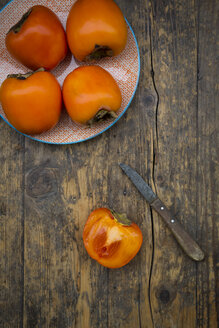 Whole and sliced kaki persimmons and a kitchen knife - LVF004101