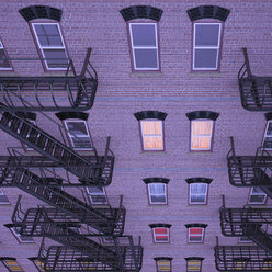 Facade of multi-family house with fire escape staircases at blue hour, 3D Rendering - UWF000646