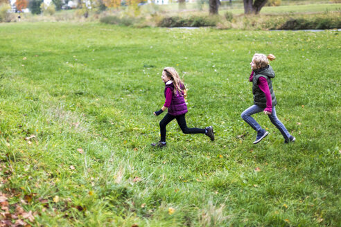 Boy and girl running over a meadow - SARF002268