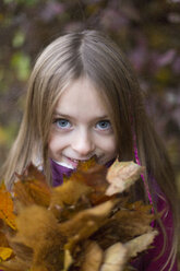 Porträt eines Mädchens, das einen Strauß Herbstblätter hält - SARF002269