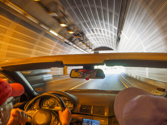 Switzerland, Ticino, Valle Maggia, senior couple in convertible car in tunnel - LAF001519