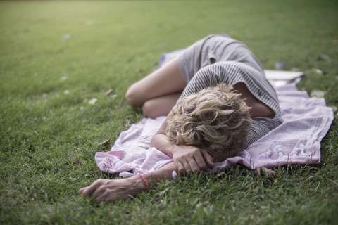 Woman lying on blanket in meadow stock photo