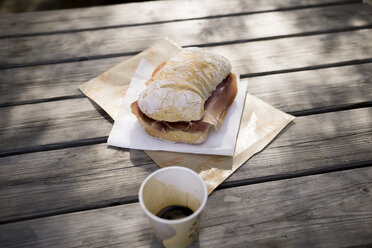 Ciabatta mit Parmaschinken auf Holztisch im Freien - RIBF000358