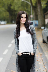 Portrait of smiling young woman with hands in her pockets - GDF000886