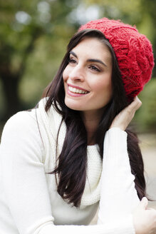 Porträt einer lächelnden jungen Frau mit roter Wollmütze - GDF000896