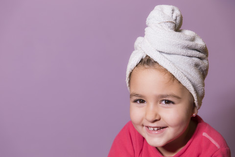 Portrait of smiling little girl wearing towel turban stock photo