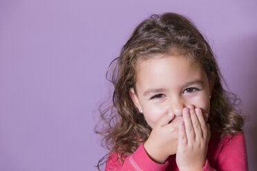 Porträt eines lachenden kleinen Mädchens, das den Mund mit den Händen bedeckt - ERLF000076