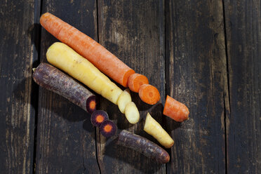 Three different sorts of sliced carrots on dark wood - CSF026592