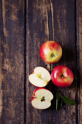 Whole and sliced red apples on dark wood - CSF026645