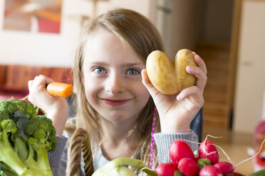 Porträt eines lächelnden Mädchens mit frischem Gemüse - SARF002281