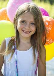 Portrait of smiling little girl with balloons - SARF002288